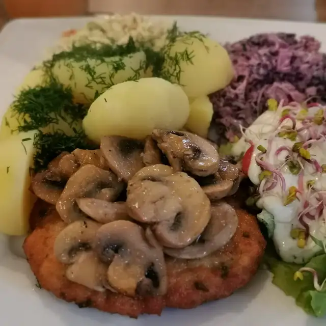 Kotlet z duszonymi pieczarkami, ziemniakami i surówkami